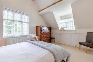 a bedroom with a bed and a chair and windows at 5 Bed in Belper oc-b29775 in Belper