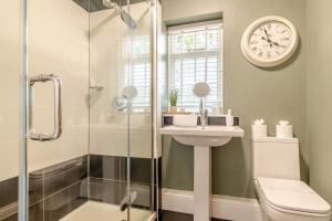 a bathroom with a shower and a sink and a clock at 5 Bed in Belper oc-b29775 in Belper +32 photos