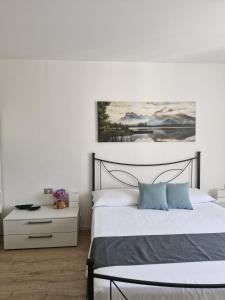 a bedroom with a bed and a painting on the wall at La Casa Verde - Apartment in Lasino
