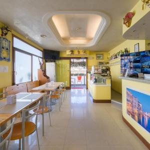 a restaurant with tables and chairs and a kitchen at Albergo Nuova Aurora - FREE PARKING & BREAKFAST in Marghera