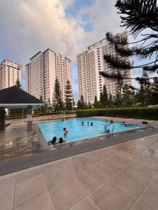 a group of people in a swimming pool with tall buildings at Casa Lumière in Tagaytay