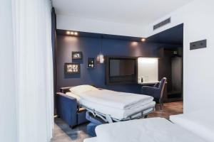 ein Krankenhausbett in einem Zimmer mit blauen Wänden in der Unterkunft LINDEMANN'S in Berlin