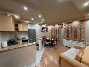 a kitchen and living room with a table and chairs at Sunset Apartman Obrenovac,Centar in Obrenovac