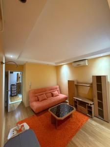 a living room with a couch and a table at Sunset Apartman Obrenovac,Centar in Obrenovac +3 photos