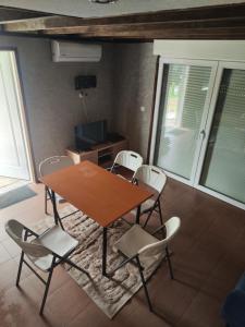 a wooden table and chairs in a room with windows at Imprezowy domek in Żeleźnikowa Wielka +5 photos