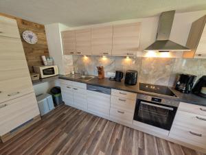 a kitchen with wooden cabinets and a stove top oven at Lipperhof in Schwendau +7 photos