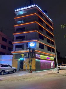 a tall building with a car parked in front of it at Hospedaje W TAWA in Lima