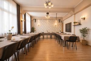 a dining room with tables and chairs and a chalkboard at Hotel Aslan in Tarnowskie Góry