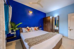 a bedroom with blue walls and a large bed at 2bhk Excella Apartment at Vagator in Vagator +24 photos