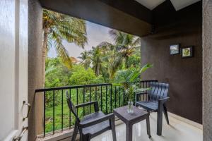 a balcony with two chairs and a table at 2bhk Excella Apartment at Vagator in Vagator