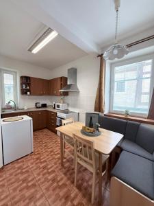 a kitchen and dining room with a table and a couch at Hřensko 27 Apartmány in Hřensko