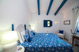 a bedroom with a bed with a blue bedspread at Descansadero in Bolonia