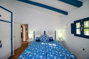a bedroom with a bed with blue sheets and blue pillows at Descansadero in Bolonia +8 photos