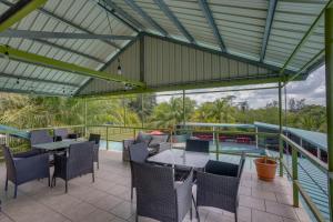 a patio with tables and chairs and a pool at Hill Garden Boutique Resort in San Ignacio