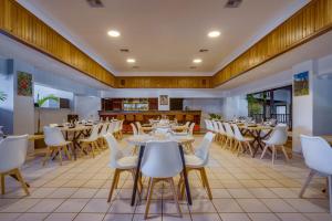 a dining room with tables and white chairs at Hill Garden Boutique Resort in San Ignacio