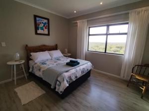 a bedroom with a bed and a large window at Intimi2 in Yzerfontein