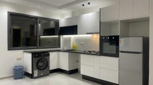 a kitchen with white cabinets and a washer and dryer at Spinoza House Agadir City Apartment in Agadir