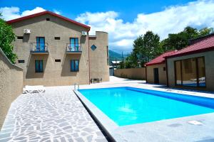 a swimming pool in front of a house at Hotel Kvarlis Mtebi in Kvareli