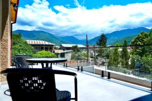 a table on a balcony with a view of mountains at Hotel Kvarlis Mtebi in Kvareli