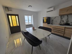 a kitchen with a table and chairs in a room at Smiljana 36 in Klimno