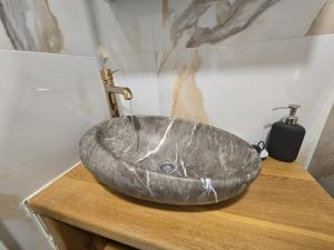a bathroom with a stone sink on a wooden table at Smiljana 36 in Klimno
