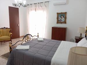 a bedroom with a large bed with a blue blanket at Elico Di Sicilia home B in Sambuca di Sicilia