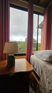 a bedroom with a bed and a table with a lamp at Monteverde Monkey Hostel in Monteverde Costa Rica