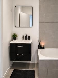 a bathroom with a sink and a tub and a mirror at Maison Traversière in Long de Bout