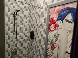 a bathroom with a shower with a painting of a woman at kyoto b&b in Ostend +22 photos