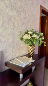 a vase filled with white flowers on a table at Casa Cataleia VILLA INN in Ponte de Lima
