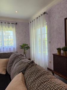 a bedroom with a large bed and two windows at Casa Cataleia VILLA INN in Ponte de Lima