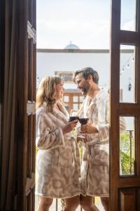 a man and woman in robes standing in a window at Tres Fuentes Dickinson Hotel Boutique in San Miguel de Allende