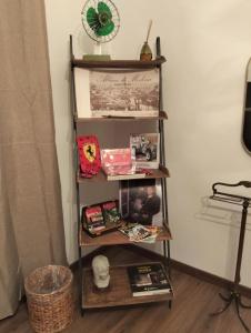 a book shelf with books and other items on it at B&B La Torretta dei Ricordi in Formigine