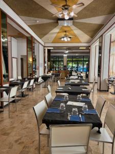 ein Esszimmer mit Tischen und Stühlen und einer Decke in der Unterkunft Hotel Caracas in Cattolica