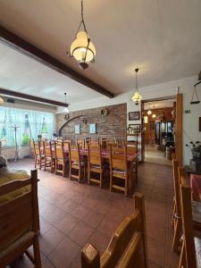 a dining room with wooden chairs and a brick wall at Pizzerie Osičko in Bystřice pod Hostýnem