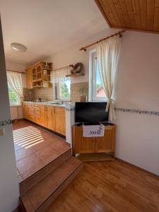 a large kitchen with wooden cabinets and a window at Pizzerie Osičko in Bystřice pod Hostýnem