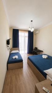 a hotel room with two beds and a table at Sunny Hotel in Kobuleti +20 photos