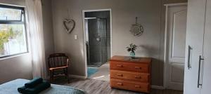 a bedroom with a bed and a dresser and a shower at Intimi2 in Yzerfontein +42 photos