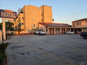 a motel with cars parked in a parking lot at Evans Motel in Maywood