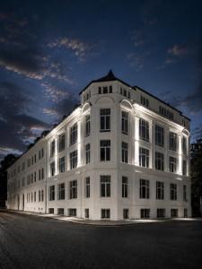 a large white building is lit up at night at White House Meerane - Loft Sky in Meerane