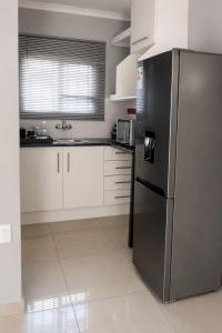 a kitchen with a stainless steel refrigerator and white cabinets at R&N Hosts in Maseru
