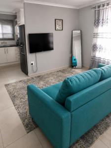 a blue couch in a living room with a tv at R&N Hosts in Maseru