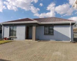 a small white house with a tile roof at R&N Hosts in Maseru