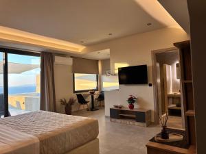 a hotel room with a bed and a television at Bevimar Suites with Private Pool and Non Heated Jacuzzi in Santorini +48 photos