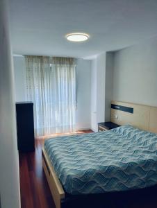 a bedroom with a bed with a blue comforter at apartamento victor in Cee