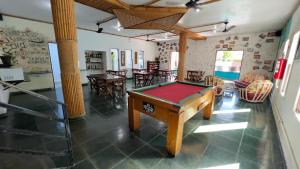 a room with a pool table in the middle of it at Pousada Tribo Ubatuba in Ubatuba
