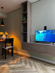 a living room with a flat screen tv on a cabinet at Modern Olive Home in Căuşeni