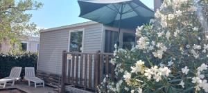 a tiny house with a blue umbrella on a deck at El sol in Port-la-Nouvelle +6 photos
