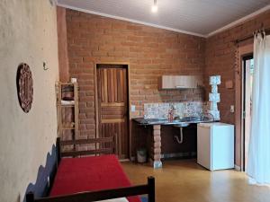 a brick walled kitchen with a counter and a refrigerator at Vila Chapada Alta - Chapada dos Veadeiros in Alto Paraíso de Goiás