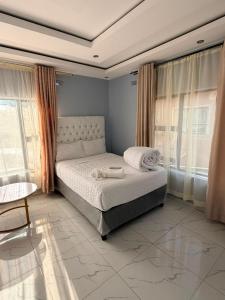 a bedroom with a bed in a room with windows at Diana's Place Guest house in Nyanda